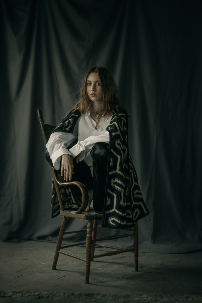White shirt by Hugo Boss Asymmetrical black trousers by Patuna Print knit cape by Maria Aristidou Necklace, ring by Harpo